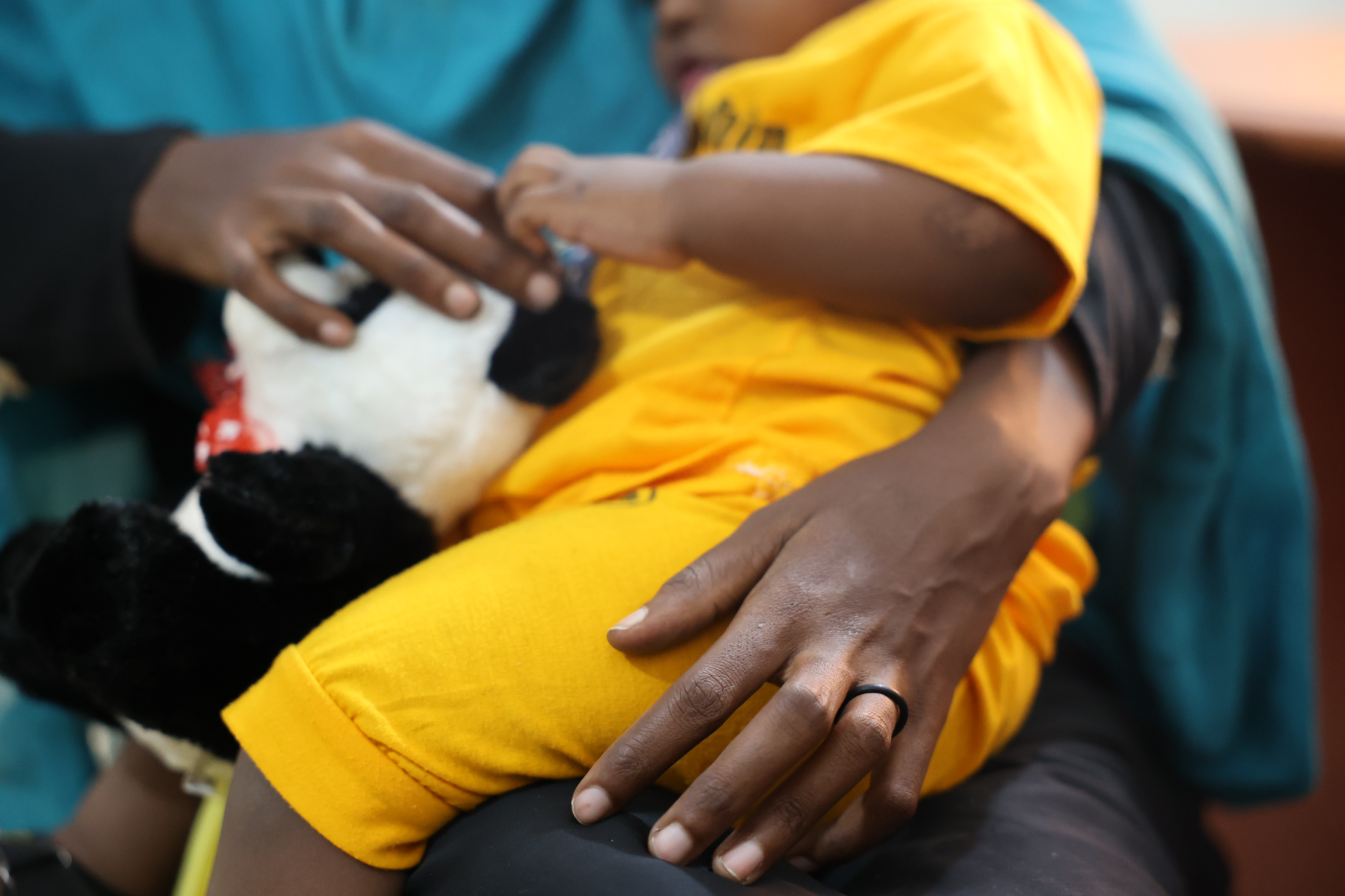 Aisha holds her cooing one year old son at the IOM Migration Response Centre Health facility in Aden Yemen (Eva Sibanda/IOM 2023)  